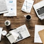 un bureau avec des papiers, un pc, une calculatrice...