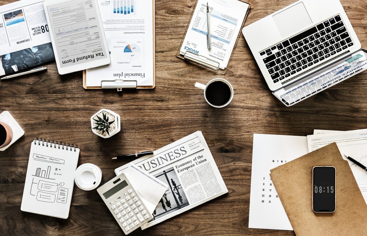 un bureau avec des papiers, un pc, une calculatrice...